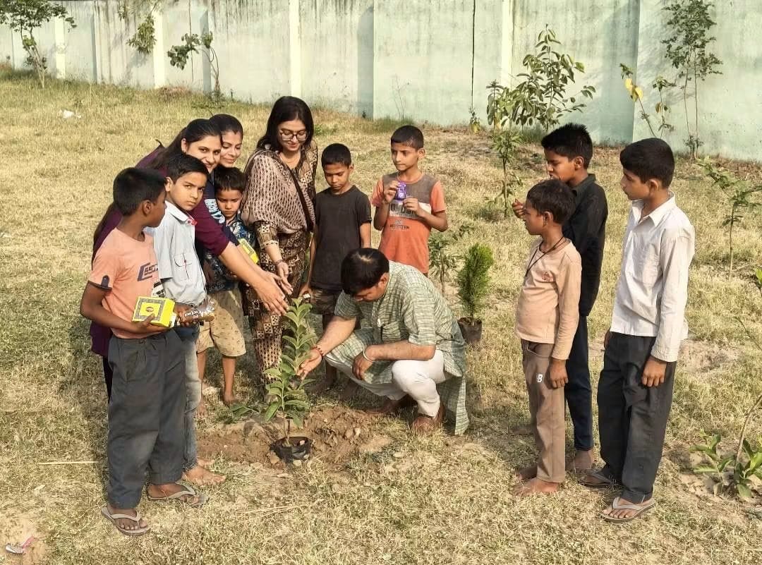 Children, volunteers and community members planting a sapling together